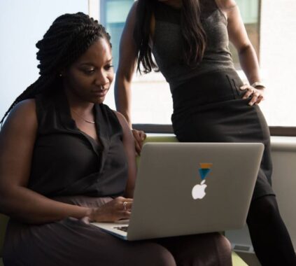 A female professional explaining 'What is contact center solutions_' to her colleague using a presentation or visual aids.