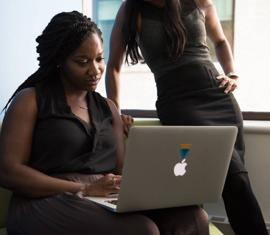 A female professional explaining 'What is contact center solutions_' to her colleague using a presentation or visual aids.