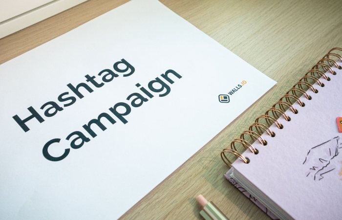 A clean office desk setup featuring hashtag campaign marketing materials and a planner.
