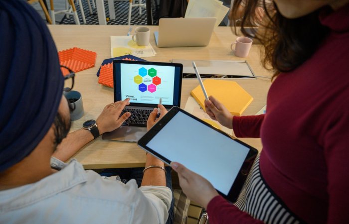 Creative meeting with digital devices in a modern office, showcasing teamwork and collaboration.