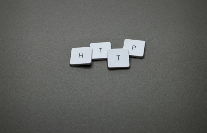 High-angle photo of keyboard tiles spelling HTTP on a dark background.