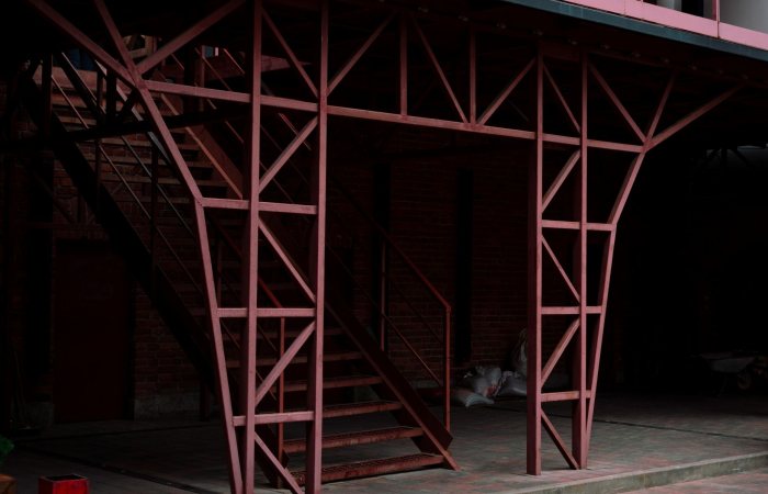 Close-up of a red metal staircase in a modern industrial setting.