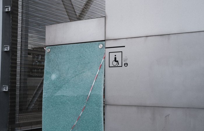 Urban architectural facade featuring an accessibility symbol for wheelchair access.